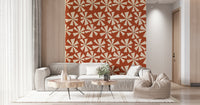 Patterned wallpaper with abstract cream blooms over a muted terracotta background.