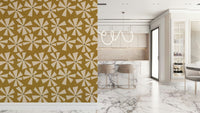 Mid-century inspired wallpaper with geometric pinwheel blooms in cream and warm golden tones.