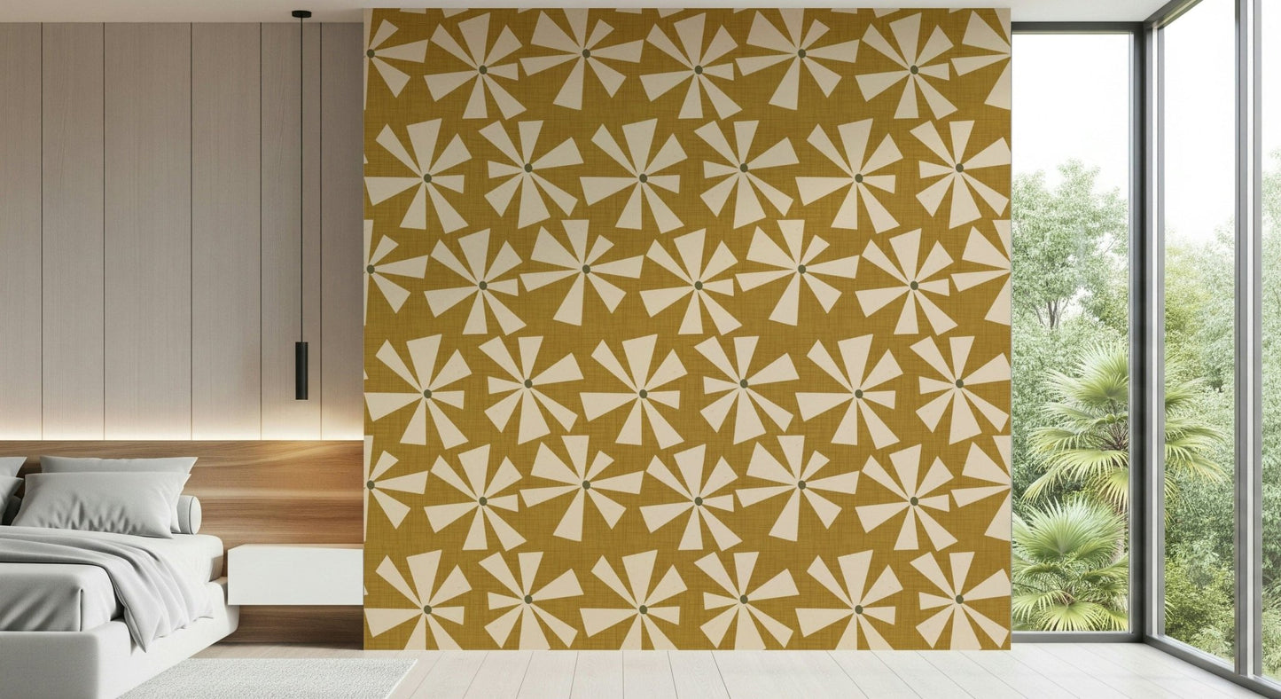 Mid-century wallpaper with dynamic starburst blooms in cream on a mustard yellow surface.
