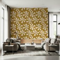 Bold retro wallpaper featuring cream sunburst petals across a warm golden-yellow field.