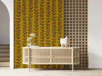 Mustard yellow wallpaper decorated with repeating vine stripes and outlined retro-style leaf motifs.