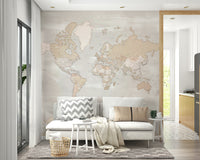 Rustic World Map wallpaper in beige behind a white sofa with grey chevron and tan cushions in a Scandi living room