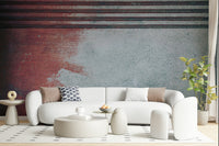 Rustic Rouge Concrete wallpaper mural in red and gray behind a white curved sofa with a polka-dot pillow