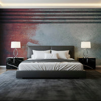 Rustic Rouge Concrete wallpaper mural in red and gray behind a dark leather bed and marble nightstands