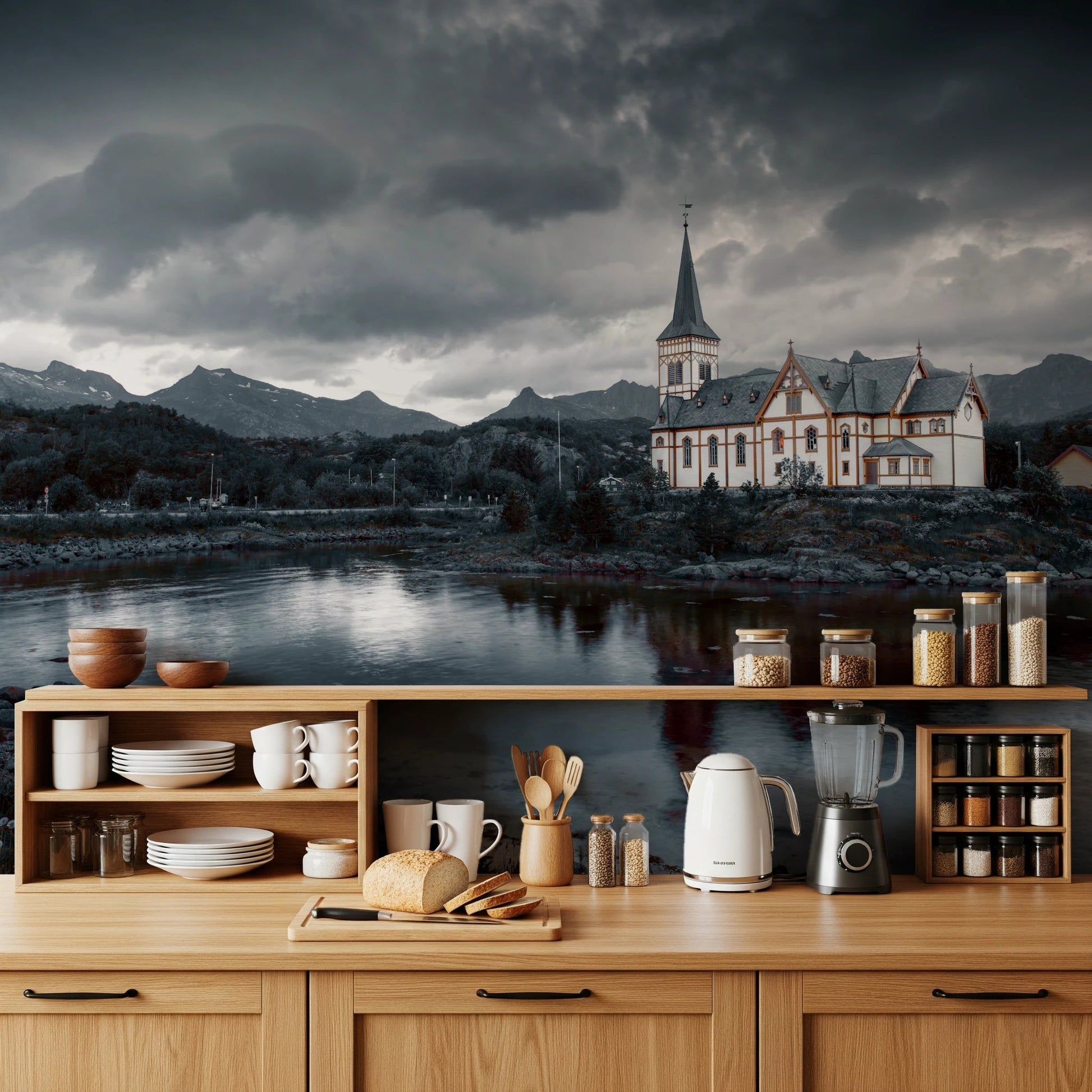 Sacred Shores wallpaper mural of a dramatic lakeside church on a kitchen wall above light wood cabinets and open shelves