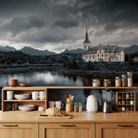 Sacred Shores wallpaper mural of a dramatic lakeside church on a kitchen wall above light wood cabinets and open shelves