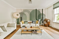 Sage Green Archways wallpaper mural behind two white sofas and a large ceramic urn in a bright living room