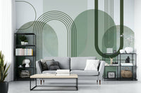 Sage Green Archways wallpaper mural behind a grey sofa and black metal shelving in a living room