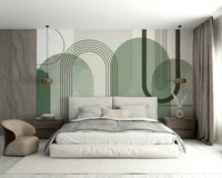 Sage Green Archways wallpaper mural on the headboard wall of a bedroom with grey bedding and a tan accent chair