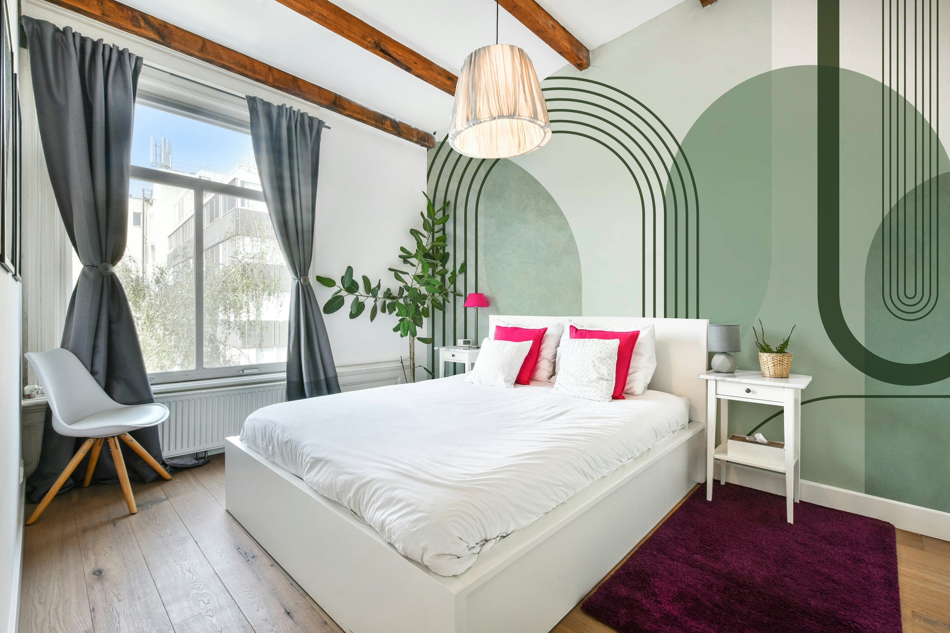 Sage Green Archways wallpaper mural in a bedroom with a white bed, hot-pink cushions and a magenta rug