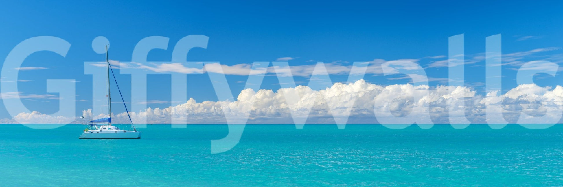 Catamaran on turquoise water wall mural design.

