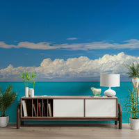 Ocean wall mural with white sailing boat and blue sky.

