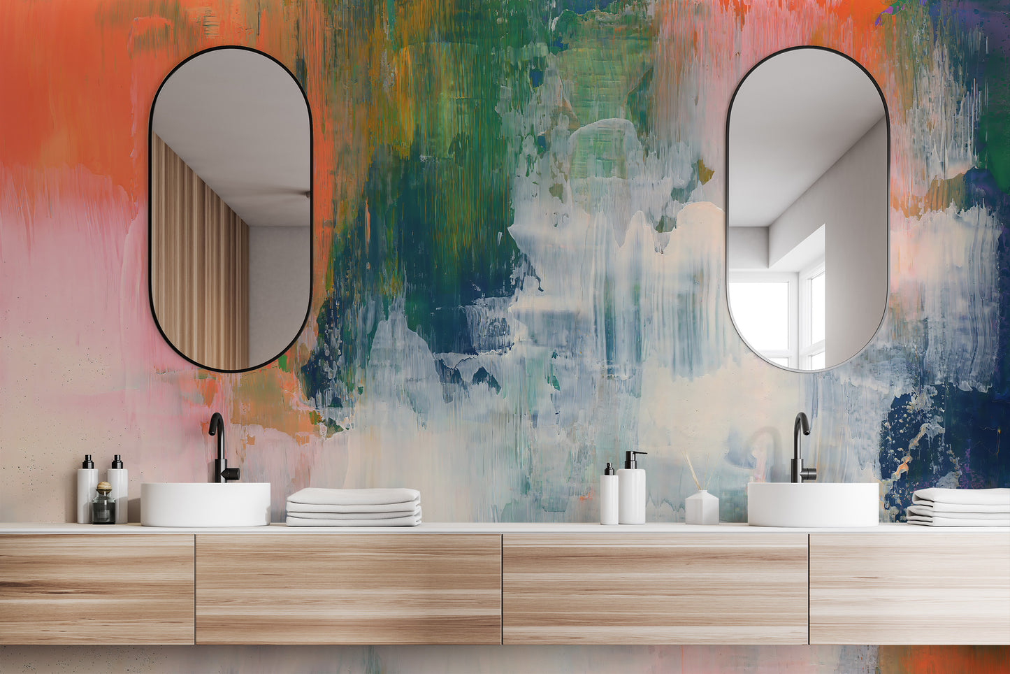 Abstract Brushstroke wallpaper mural in bright colors behind two oval mirrors and dual sinks in a bathroom
