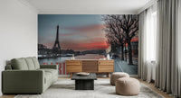 Seine and Eiffel Tower Silhouette wallpaper mural at sunset behind a green sofa with a wood sideboard