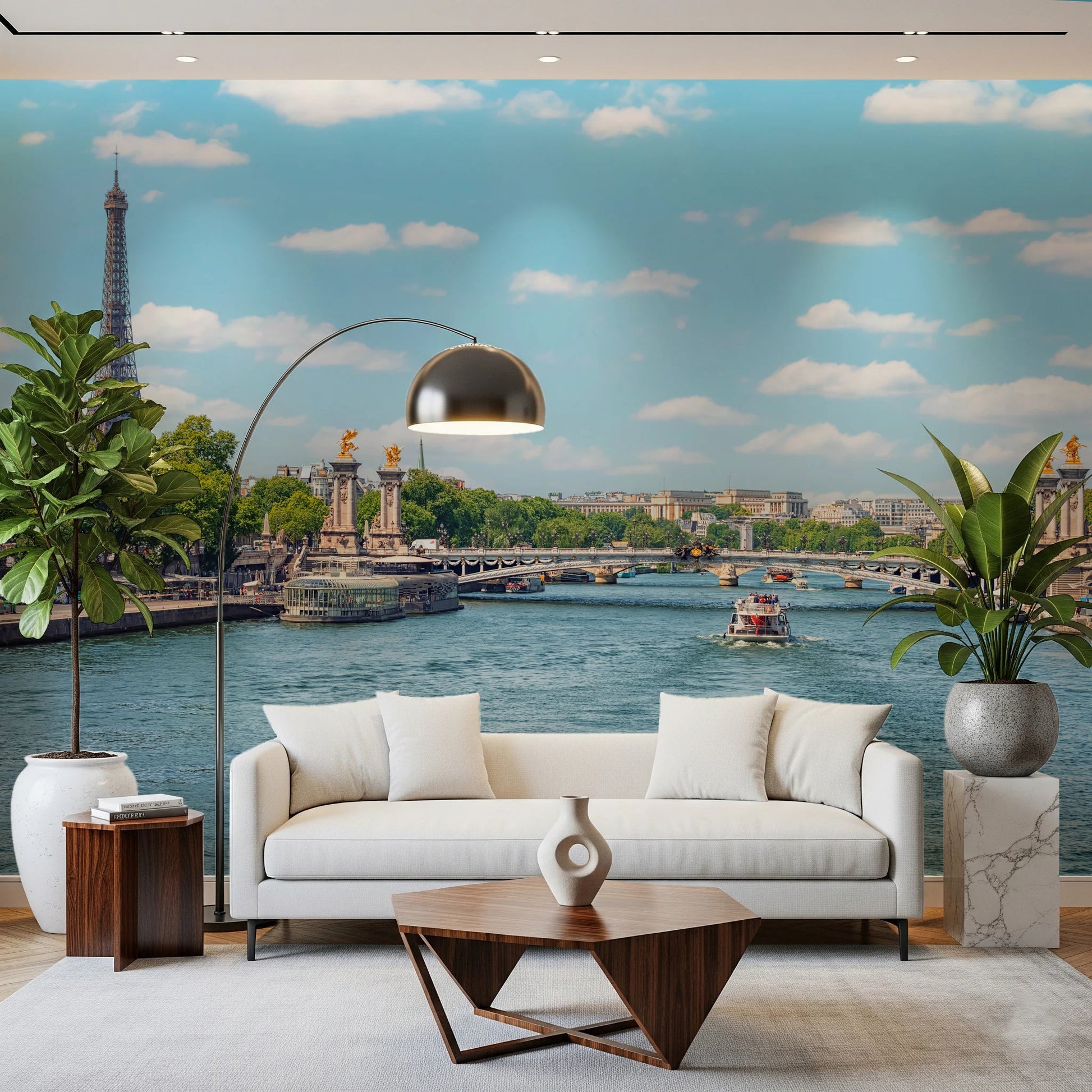 Seine Reflections wallpaper mural showing the river and bridge behind a white sofa, arc lamp and fiddle-leaf plants