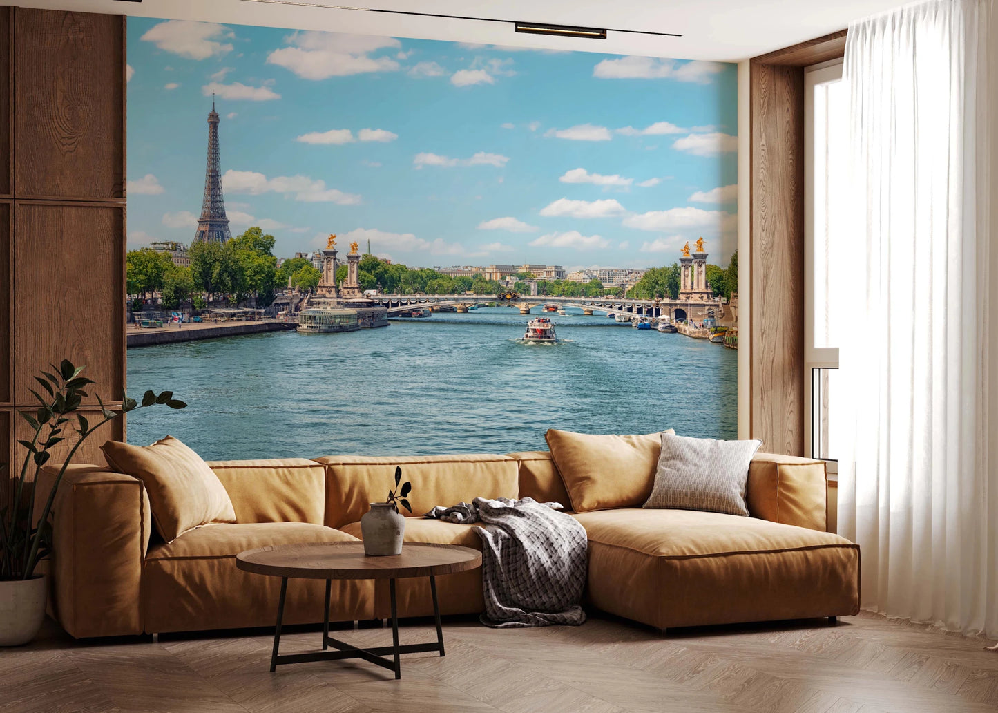 Seine Reflections wallpaper mural showing Paris and the Seine behind a camel sectional sofa and wood-panel wall in a living room