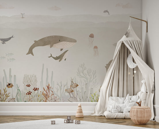 Sensational Sea Brown wallpaper mural with watercolor whales and jellyfish in a kids room with a beige canopy