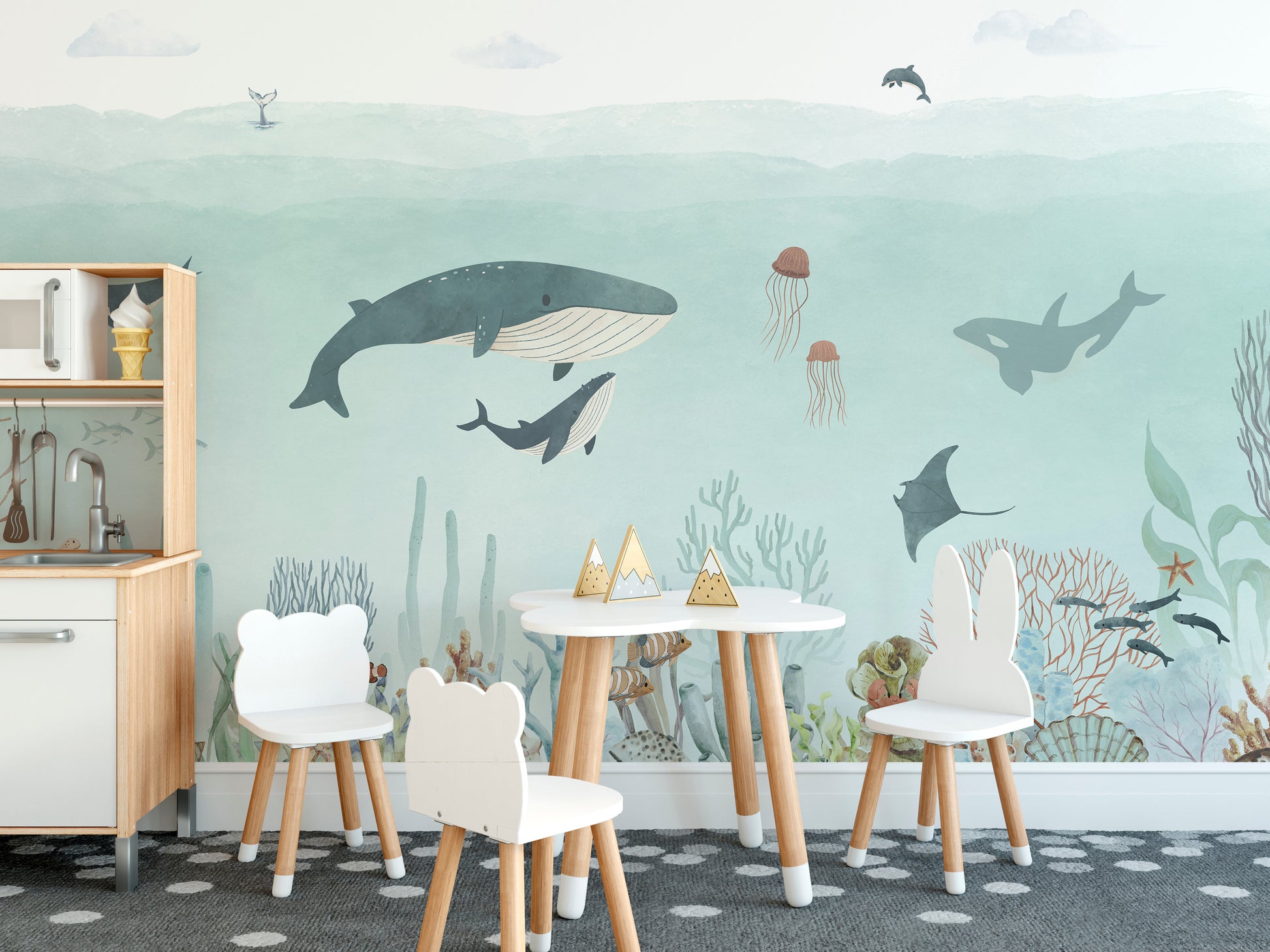 Sensational Sea wallpaper mural of whales, an orca and coral reef behind a kids play table and chairs