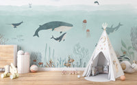 Sensational Sea wallpaper mural with whales and jellyfish in teal water beside a white teepee in a kids room