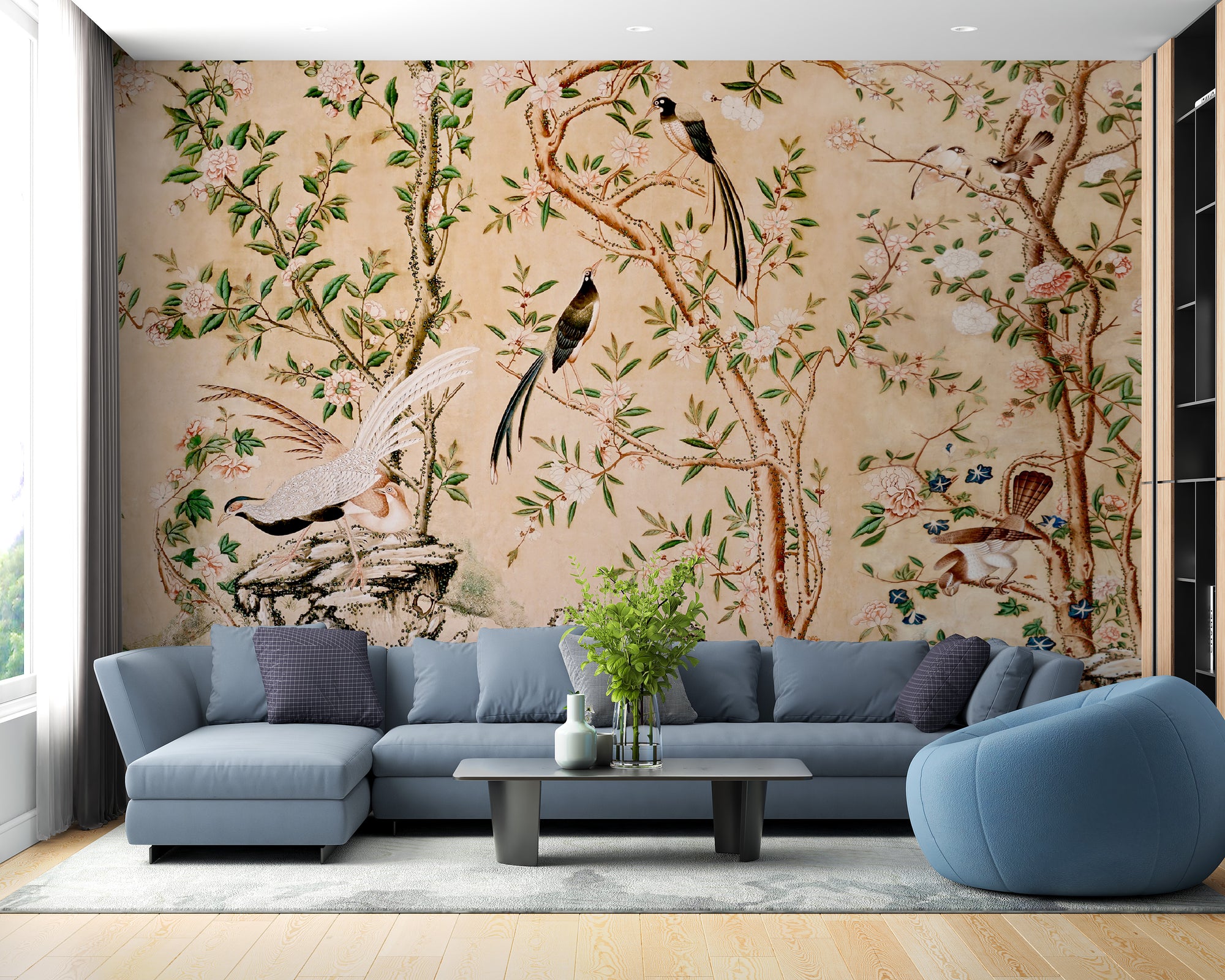 Sepia Chinoiserie Chinese wallpaper mural with birds and blossoms behind a blue sectional sofa in a living room