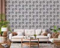Serene Blooms wallpaper with blue blooms behind a cream sofa and rattan chair framed by plants
