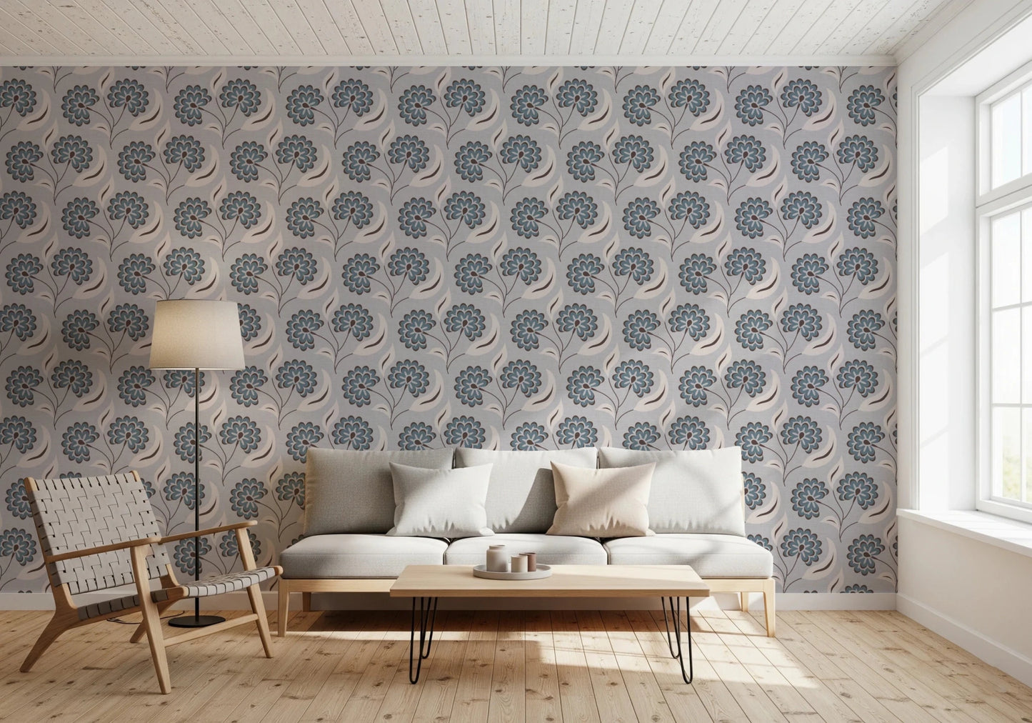 Serene Blooms wallpaper with blue blooms behind a grey sofa and hairpin-leg table in a living room