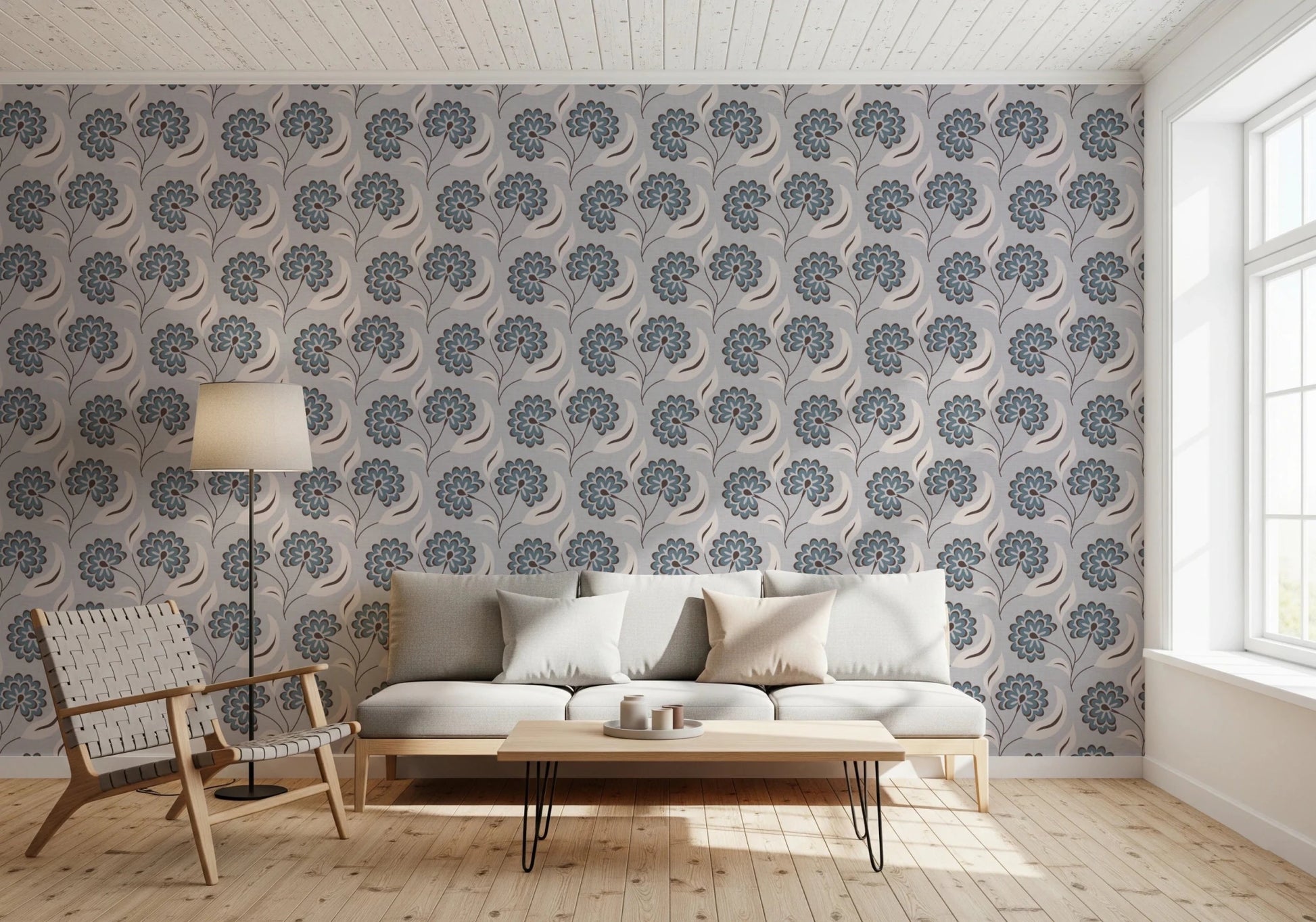 Serene Blooms wallpaper with blue blooms behind a grey sofa and hairpin-leg table in a living room
