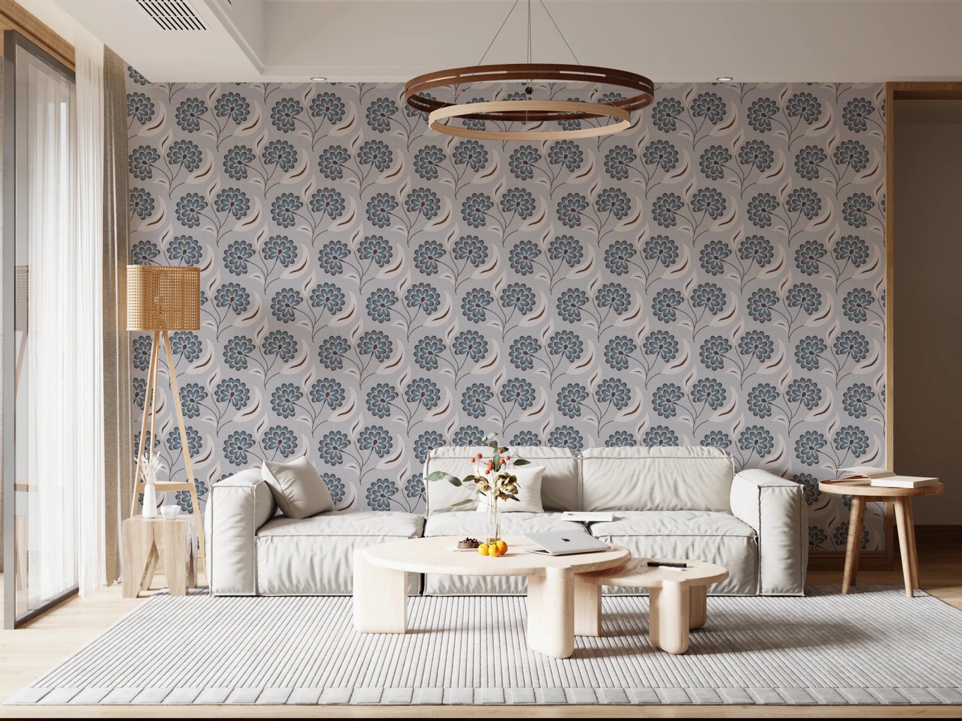 Serene Blooms wallpaper with blue blooms behind a low grey sofa under a round wood pendant light