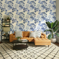 Serene Blue Botanicals wallpaper behind a tan leather sectional sofa on a Moroccan rug in a living room