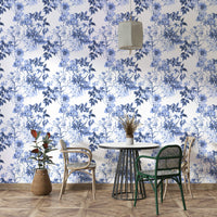 Serene Blue Botanicals wallpaper in a dining nook with a black round table and green and rattan chairs