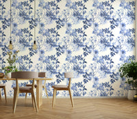Serene Blue Botanicals wallpaper in a dining room with a light wood table, chairs and hanging bulb lights
