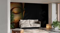 Serene Buddha Sculpted Portrait wallpaper mural in gold on black behind a beige sofa with a plant in a living room