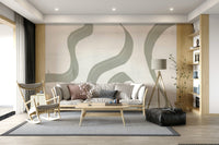 Subtle Stream wallpaper mural in sage green behind a cream sofa with wooden rocking chair and tripod lamp