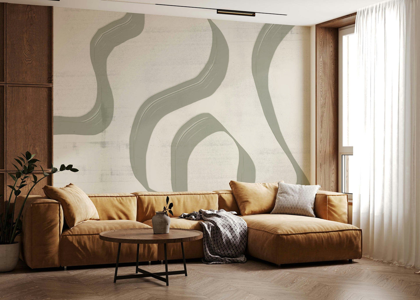 Subtle Stream wallpaper mural in sage green behind a caramel leather sectional and round wood coffee table