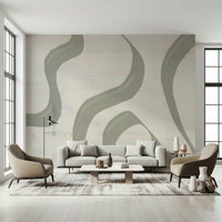 Subtle Stream wallpaper mural with sage green wavy lines on cream behind a grey sofa and two taupe armchairs