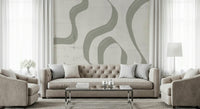Subtle Stream wallpaper mural in sage and cream behind a beige tufted sofa in a bright formal living room