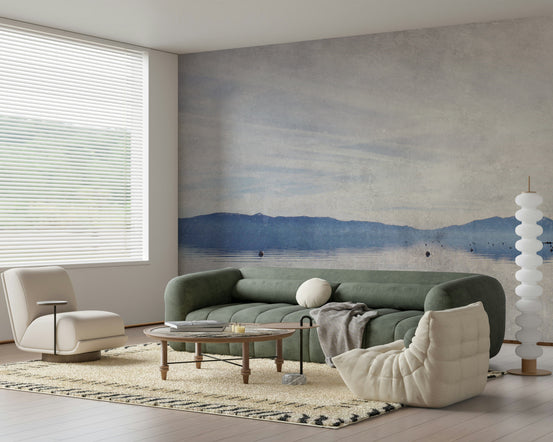 Serene Lake Vista wallpaper mural of misty blue mountains and calm water behind a green sofa in a living room
