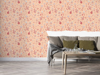 Serene Peach Tropical Garden wallpaper behind a grey sofa with olive cushions and a wood coffee table