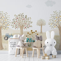 Countryside Whimsy wallpaper mural of orchard trees and a tractor behind bunny-shaped chairs and a white bunny lamp in a kids room