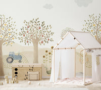 Countryside Whimsy wallpaper mural of fruit trees, blue tractor and sunflowers behind a wood toy chest and canopy bed in a nursery