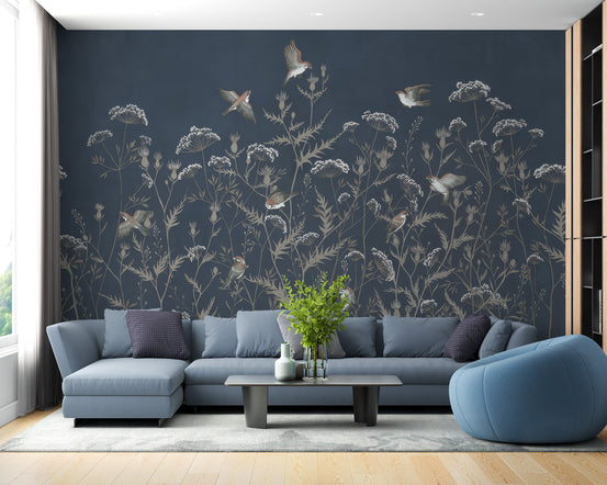 Evening Elegance Aviary wallpaper mural of birds and wildflowers on navy behind a blue sectional sofa in a living room
