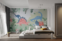 Kids Dinosaur wallpaper mural of pastel dinosaurs and ferns above a low platform bed with gray bedding in a kids room