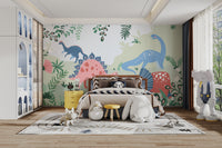 Kids Dinosaur wallpaper mural with pink and blue cartoon dinosaurs behind a wooden-headboard bed and yellow nightstand