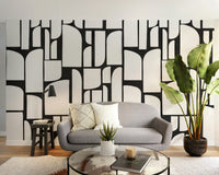 Monochrome Mosaic Tiles wallpaper mural in cream and black behind a grey check loveseat in a cozy living room