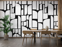 Monochrome Mosaic Tiles wallpaper mural in black and white behind a wood dining table in a bright dining room