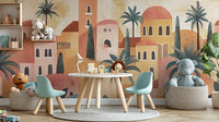 Terracotta House wallpaper mural of warm desert town and palms behind a white round table, mint chairs and lion toys in a kids room
