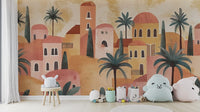 Terracotta House wallpaper mural of a clay desert village with domed houses and palms behind a white stool and plush toys in a kids room
