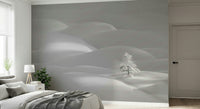 Snowscape Serenity wallpaper mural of soft white snow dunes behind a gray-dressed bed in a minimal bedroom