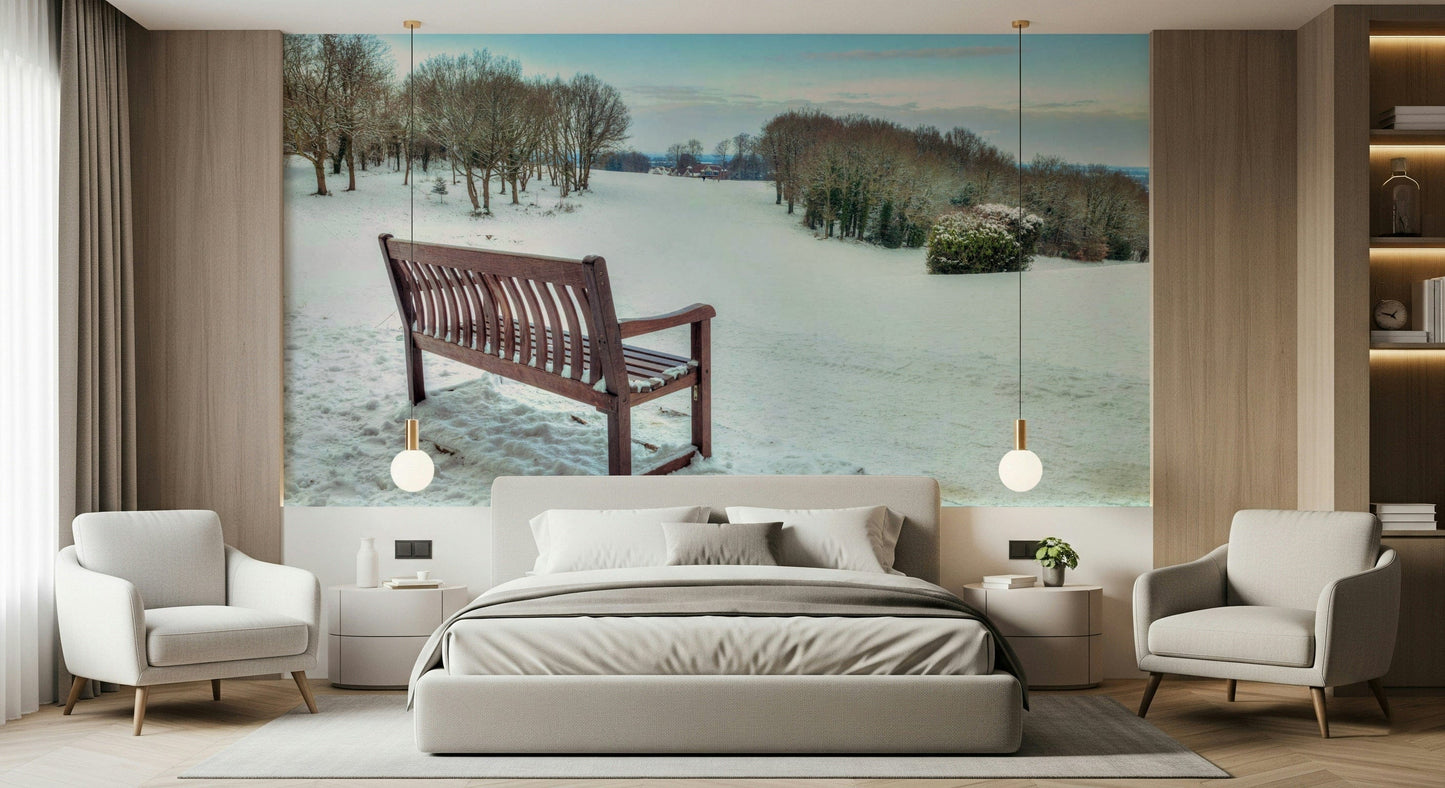 Solitary bench, pristine snow field, charming winter scene wall mural.