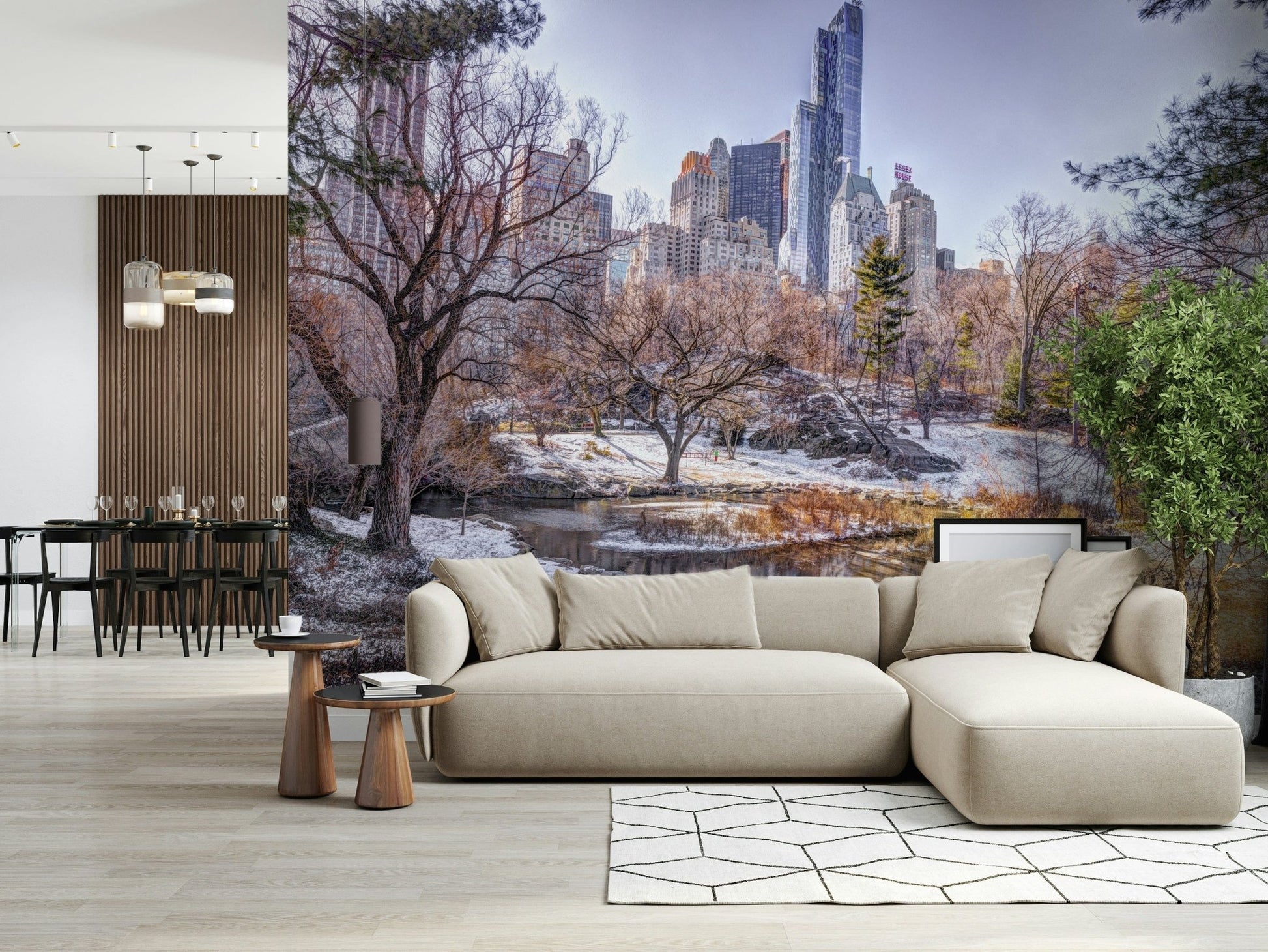 Snowy Central Park mural behind a beige sofa and chaise beside a dining area with a wood-slat divider
